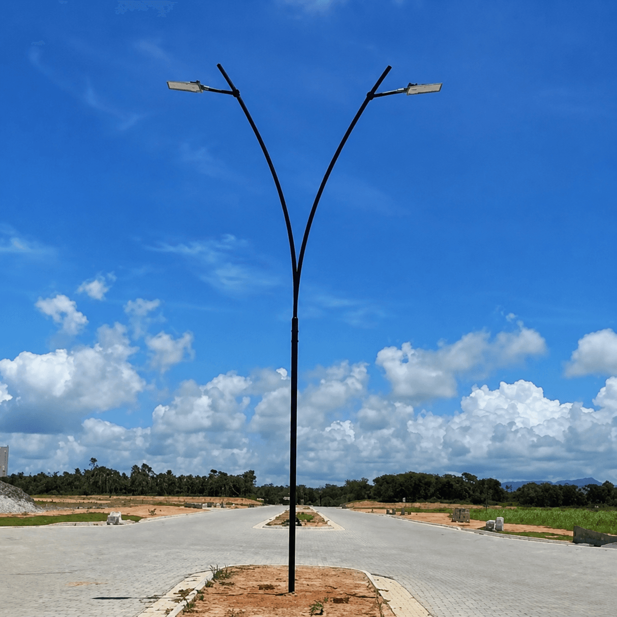 Poste curvo duplo com luminárias instalado em via pavimentada, projeto real de iluminação pública