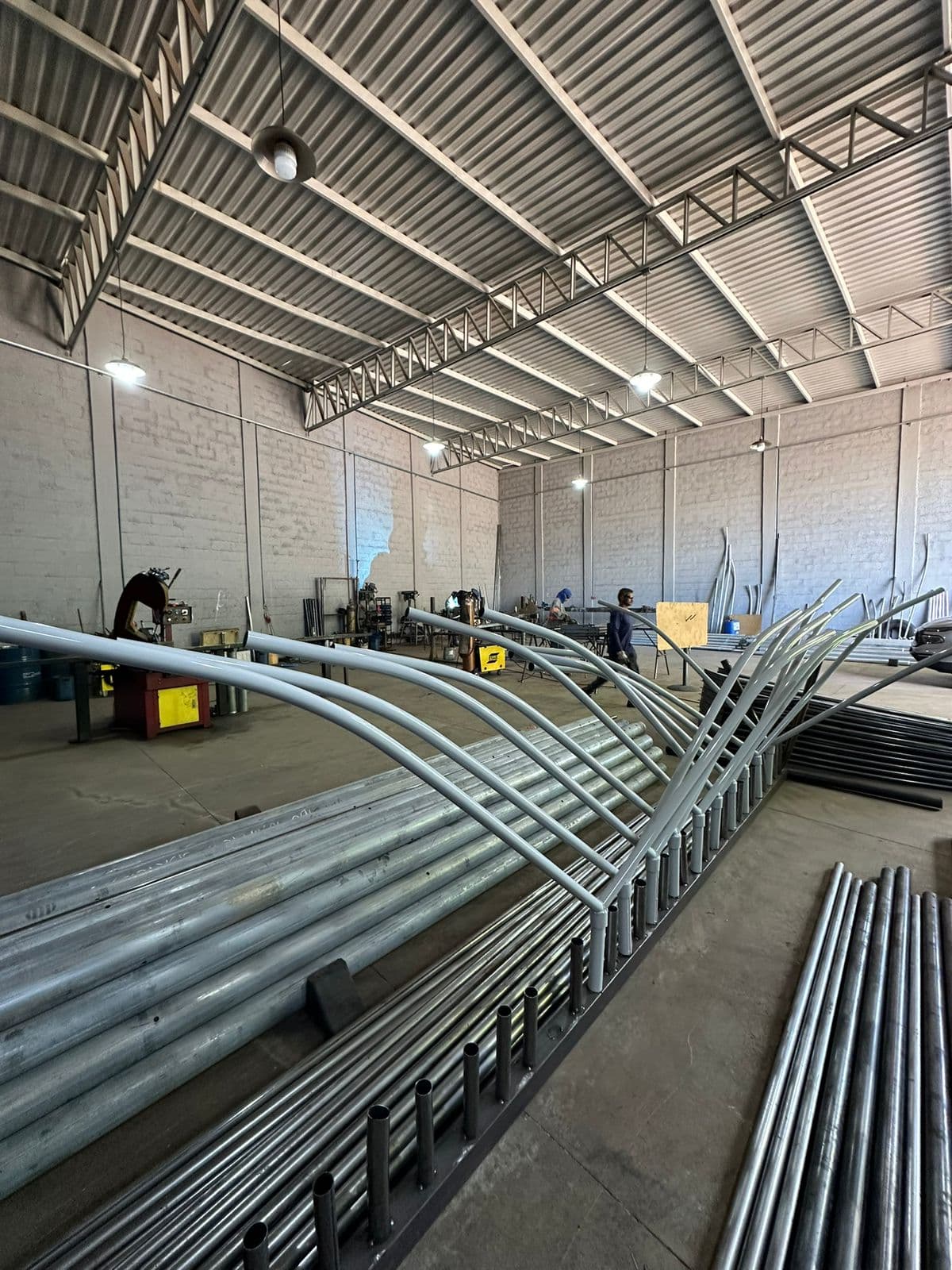 Galpão de produção da Energyn com braços curvos galvanizados dispostos em bancada